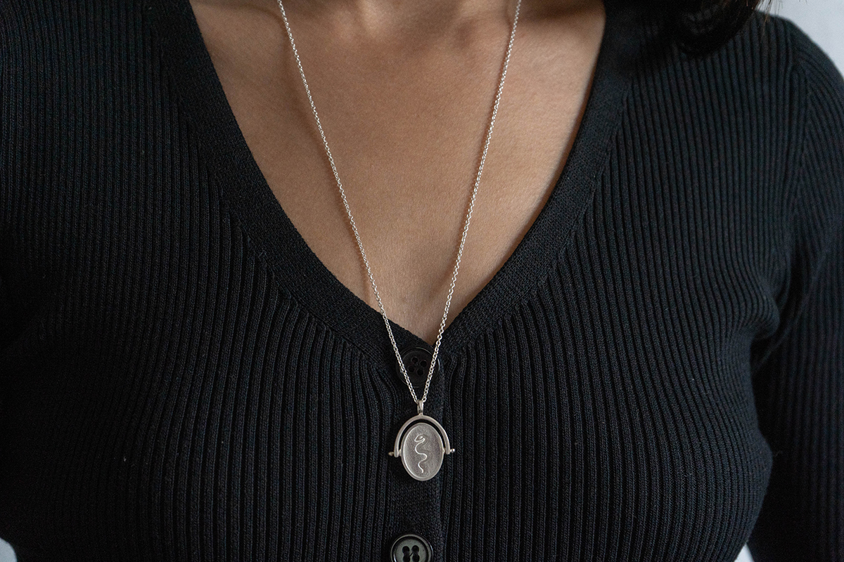 sterling silver spinner necklace snake oracle on woman wearing black v neck top