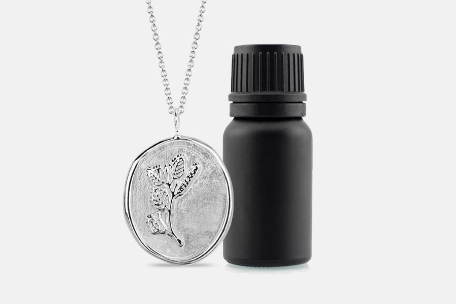 sterling silver birch necklace with matte black bottle of essential oil