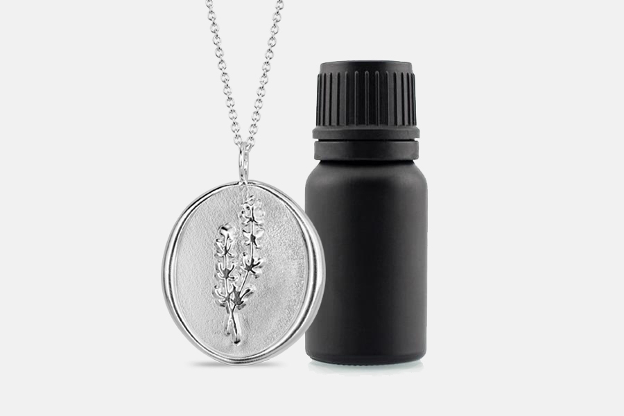 sterling silver thyme necklace with matte black bottle of essential oil