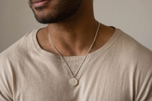 Large Astarstafur Icelandic Magic Pendant in Sterling Silver shown on model with beige t-shirt.