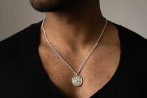 Large Vegvisir Icelandic Magic Pendant in Sterling Silver shown on model with black t-shirt.