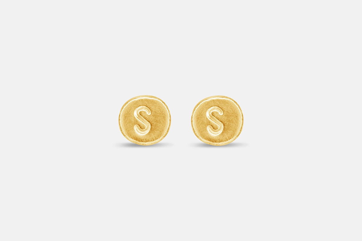 Round stamped gold letter earrings with the letter S.