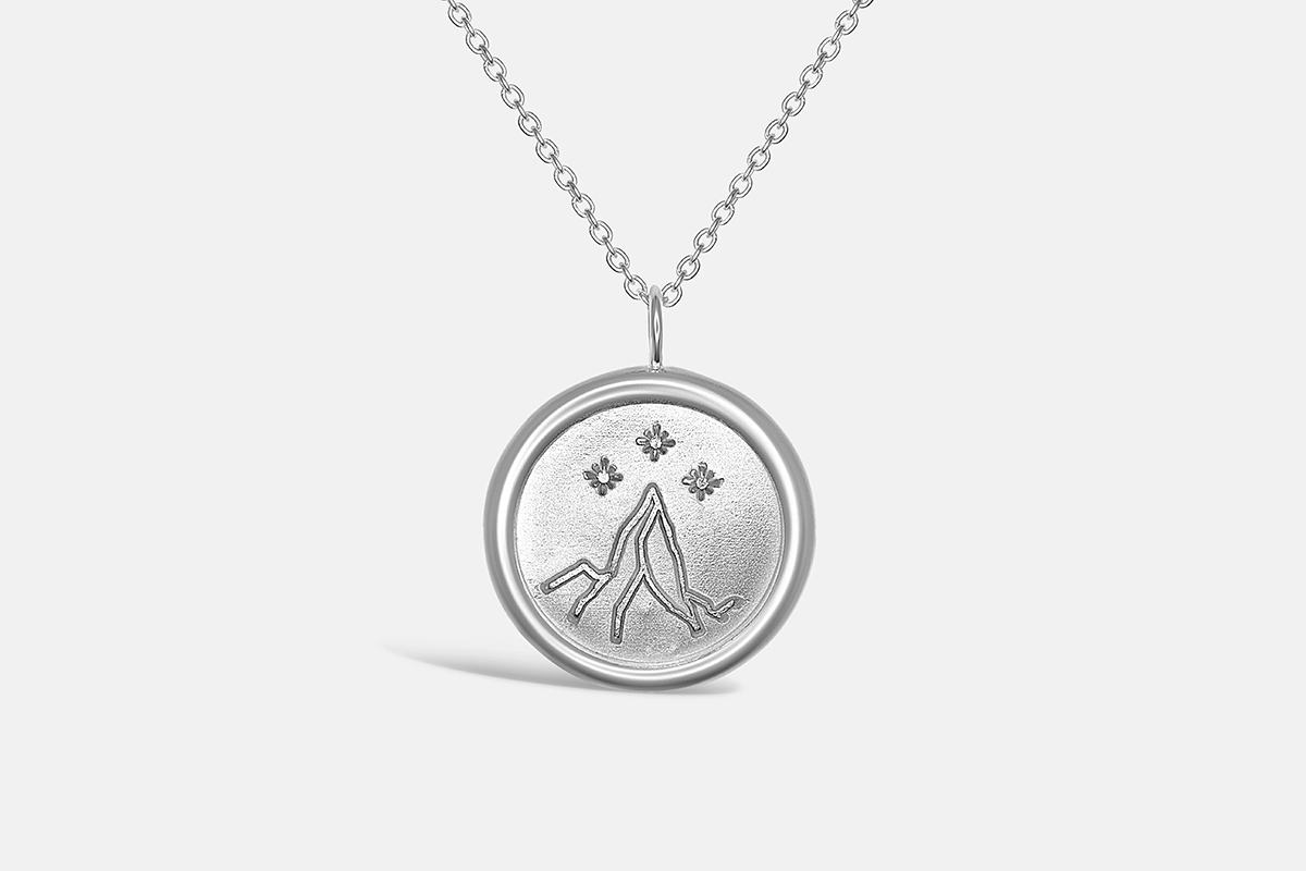 Silver pendant showing the night court insignia from the A Court of Thorns and Roses Series. A mountain peak at the centre of the pendant is topped by three small stars.